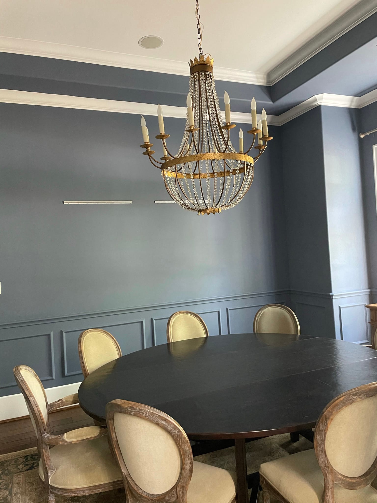 Same Houston dining room repainted in elegant slate blue with crisp white trim after interior painting